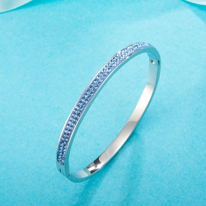 Silver stainless steel bangle featuring double rows of inlaid light blue crystals