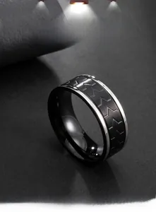 Macro shot of men's stainless steel ring with black matte chevron pattern and silver edges