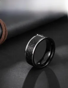 Detail of dual-tone titanium ring with matte black tire tread pattern and silver polished edges