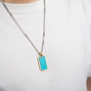 Men's rectangular necklace featuring turquoise pendant with golden sawtooth edge