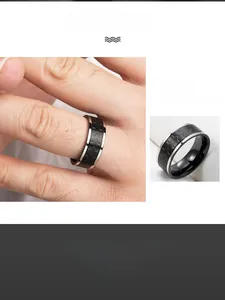 Close-up of men's wide stainless steel ring with black and silver geometric tire pattern