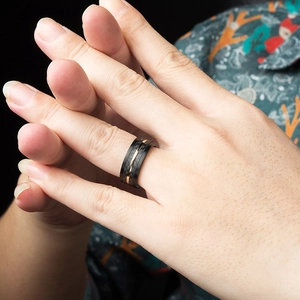 Bague bicolore pour homme en noir brossé avec ligne centrale or rose au doigt