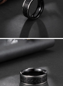 Detailed view of black matte titanium ring with silver edges and chevron tire tread grooves