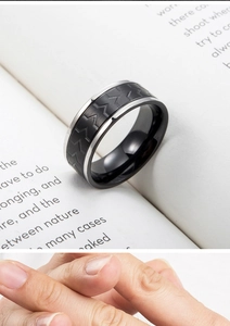 Macro shot of men's titanium steel ring with black tire tread pattern and silver edges