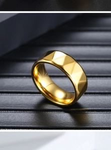 Macro shot of men's gold stainless steel ring with faceted geometric diamond pattern