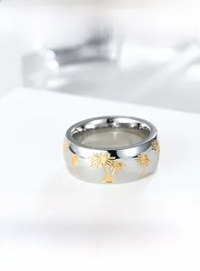 Close-up of titanium steel ring with gold palm tree pattern on a white pedestal