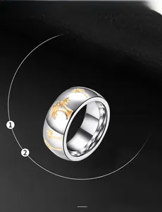 Macro shot of stainless steel ring with embossed gold palm trees on a black leather background