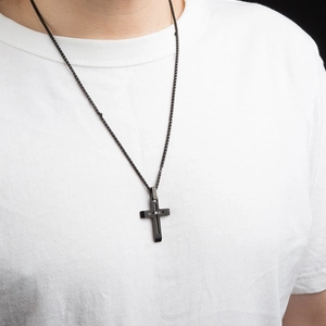 Collier croix homme en acier titane noir mat avec pierre zircone sur t-shirt blanc propre