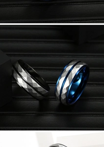 Close-up of geometric faceted titanium rings with silver, black, and blue metal textures