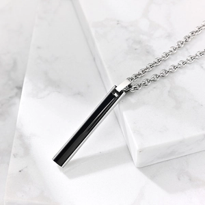 Collier minimaliste en acier inoxydable avec insert noir sur plateau en marbre