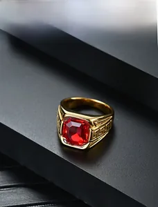 Détail de la bague en acier doré avec pierre rouge carrée et motif de méandres grecs