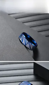 Detail shot of men's titanium ring with blue diagonal patterns and polished inner surface