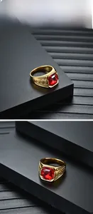 Détail de bague dorée avec pierre précieuse rouge rectangulaire et motifs de clé grecque