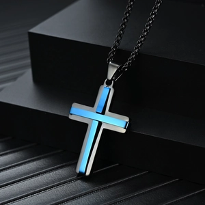 Collar con colgante de cruz de acero inoxidable en negro y azul eléctrico en pedestal