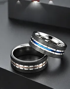 Close-up of dual-tone steel rings featuring black mesh texture and vibrant color inlays
