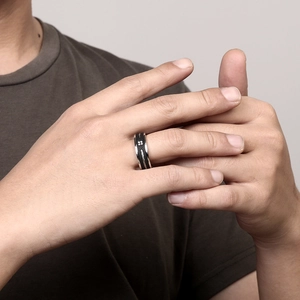 Bague pour homme en acier noir mat avec insert câble métallique portée par un modèle