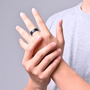 Bague pour homme en acier noir avec insert en fibre de carbone portée sur la main