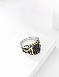 Detailed view of men's vintage silver and gold ring with black gemstones and feather relief