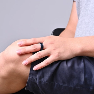 Men's black stainless steel ring with blue carbon fiber inlay worn on finger