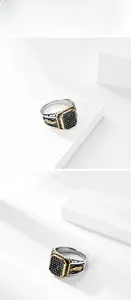 Macro detail of men's vintage signet ring featuring black gemstone and gold feather relief