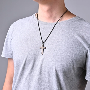 Male model wearing a cross pendant necklace with black trim and golden textured center
