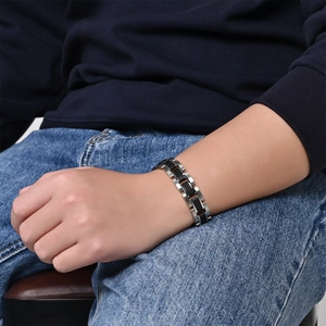 Men's silver stainless steel bracelet with black carbon fiber inlay worn on wrist
