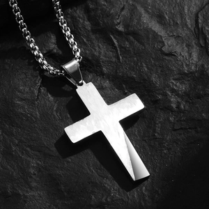Religious stainless steel cross necklace with a brushed finish on a dark stone background