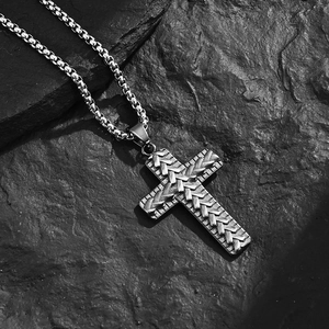Vintage men's stainless steel cross pendant with relief texture on black rock