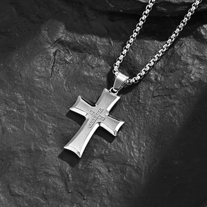 Brushed stainless steel cross necklace with micro-pave zirconia on black rock background