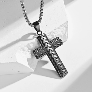 Vintage mens stainless steel cross necklace with woven texture on a white stone background