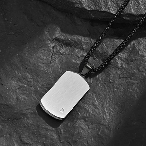 Men's stainless steel dog tag necklace with brushed finish and square stone on black rock