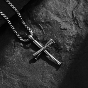 Men's vintage stainless steel baseball bat cross necklace on dark stone background