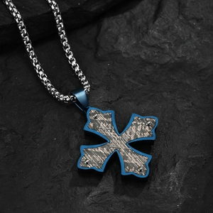 Collier croix bleue avec insert noir et chaîne box argentée sur roche sombre