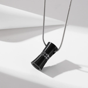 Matte black hourglass cylinder urn pendant with inlaid crystals on silver snake chain