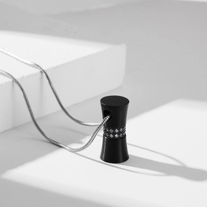 Modern drum-shaped black stainless steel cylinder pendant with inset crystals on silver chain