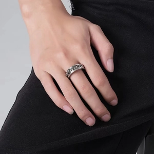 Mens vintage stainless steel chain spinner ring with textured edges on model finger