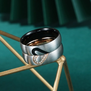 Titanium steel heart couple rings with brushed finish and zircon inlay on geometric stand