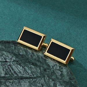 Boutons de manchette dorés classiques avec onyx noir sur socle en marbre sombre