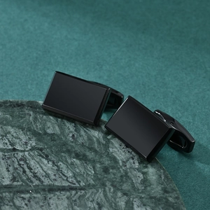 Elegant square black brushed cufflinks for men's business suits on green marble base