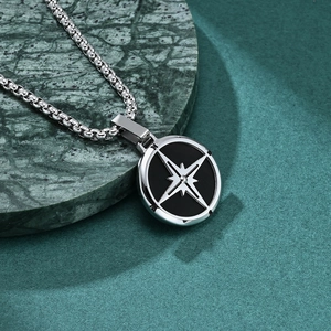 Polished compass star necklace with silver octagonal star on green marble surface