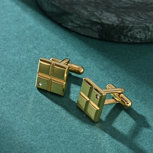 Elegant gold square cufflinks with engraved grid design and small crystal inlay