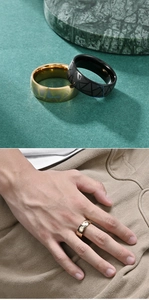 Detail of wide stainless steel rings with geometric triangle etching in gold and black