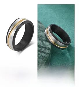 Detailed close-up of carbon fiber and brushed titanium band ring with gold accents