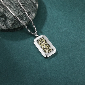 Men's stainless steel hex pendant necklace with camo inlay on a grey marble background