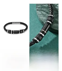 Macro detail of men's black braided leather bracelet with textured metal rings and magnetic clasp