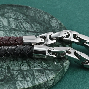 Men's leather cord bracelet with coffee bean steel clasp on marble display