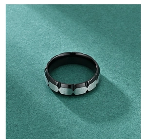 Detailed view of titanium steel ring with black and silver geometric brushed textures