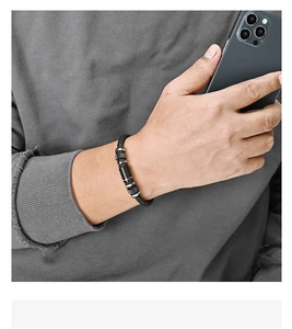 Close-up of men's braided black leather bracelet with textured silver and black metal beads