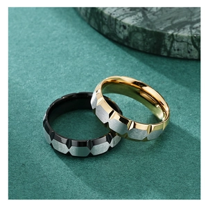 Macro detail of geometric V-groove titanium steel rings in black and rose gold finish