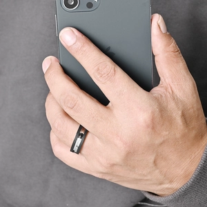 Men's knurled black titanium ring with silver accent line on model's hand